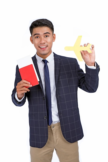 Asian young handsome cheerful business man hold passport and flight ticket