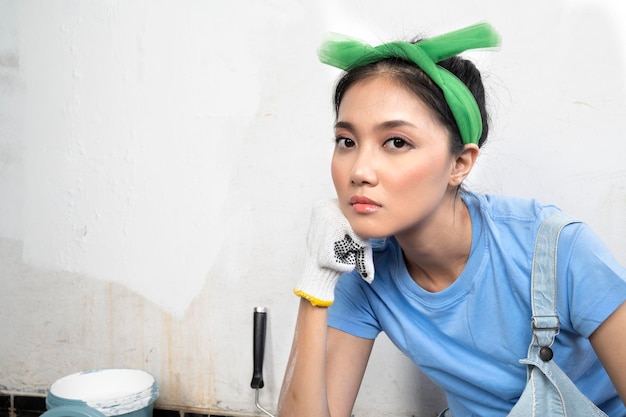 Asian young housewife in a glove with an unhappy expression