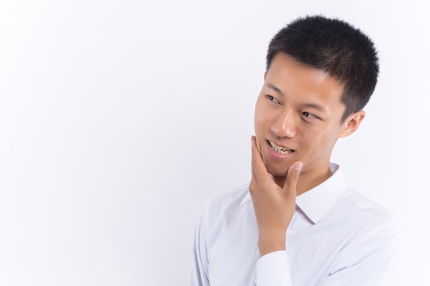 An Asian young male is touching his face