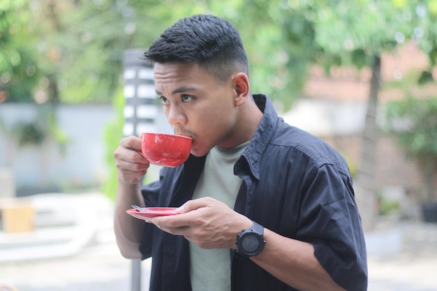 Photo asian young man drinking coffee in the morning