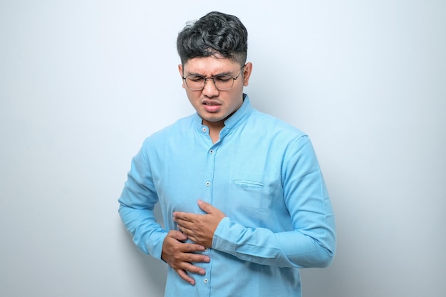 Asian young man getting stomach ache or getting abdominal pain health problem discomfort diarrhea