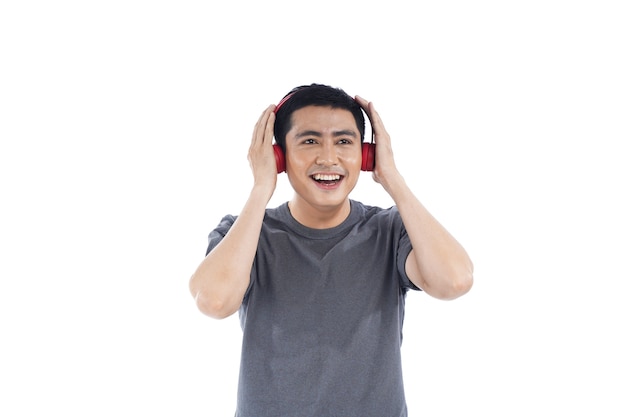 彼の携帯電話で音楽を聞いているアジアの若い男