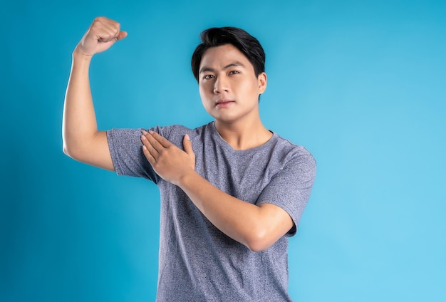 Asian young man posing on blue background