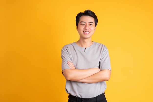 Asian young man posing on a yellow background