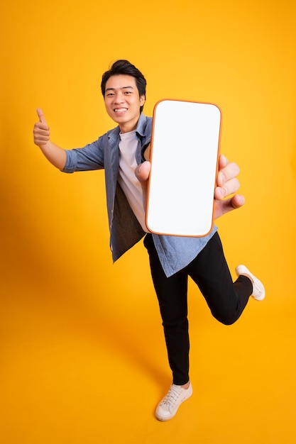 Asian young man posing on a yellow background