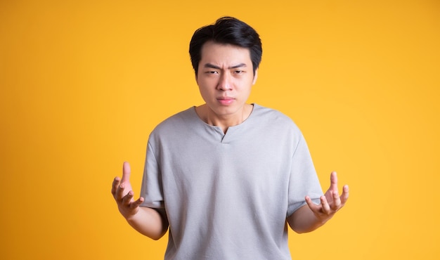 Photo asian young man posing on a yellow background