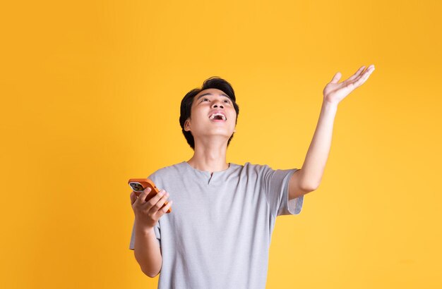 Asian young man posing on a yellow background