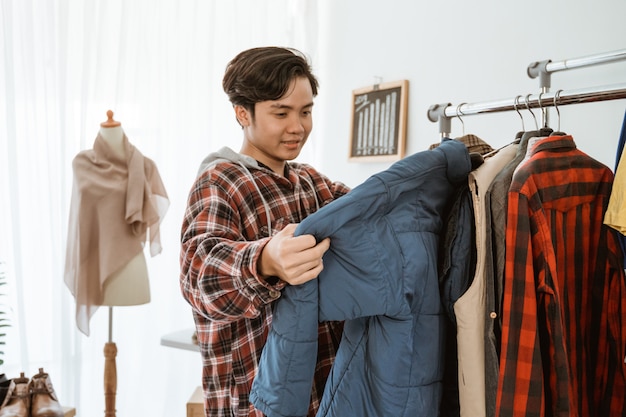 Foto acquisto asiatico del giovane in un negozio di vestiti