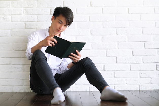 Asian young man student with books in hands