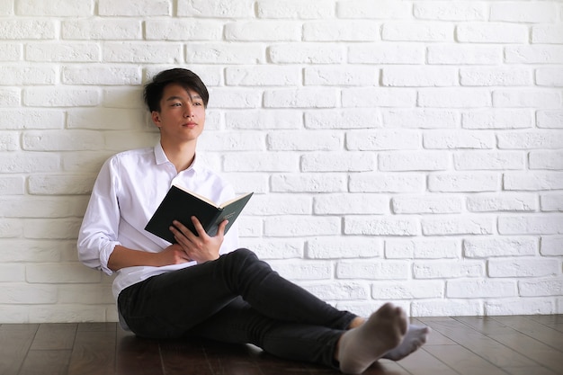 Asian young man student with books in hands