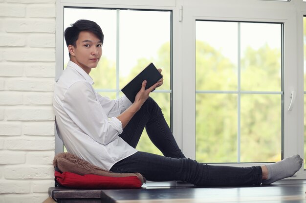 Asian young man student with books in hands