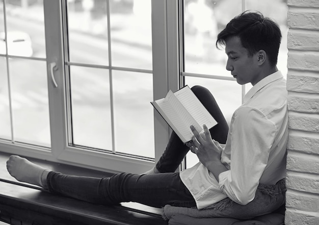 Asian young man student with books in hands