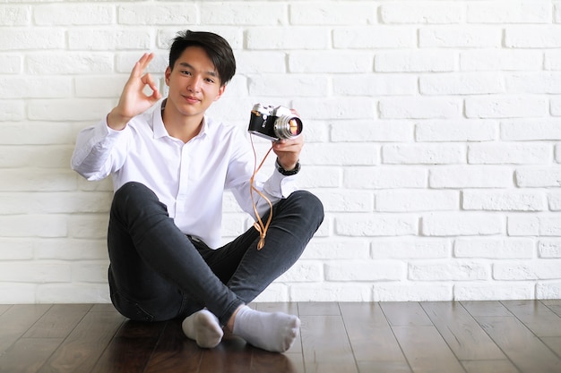 Asian young man uses a camera in the studio