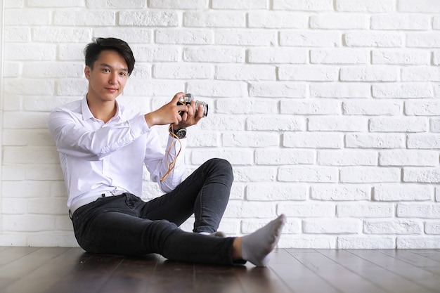 Asian young man uses a camera in the studio