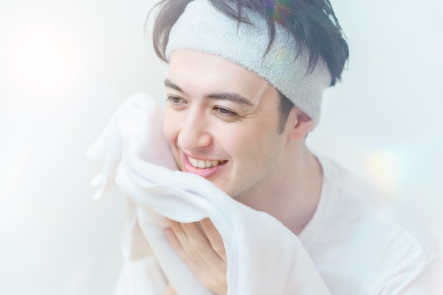 タオルで顔を拭くアジアの若い男