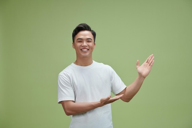 Asian young man with both hands presenting something