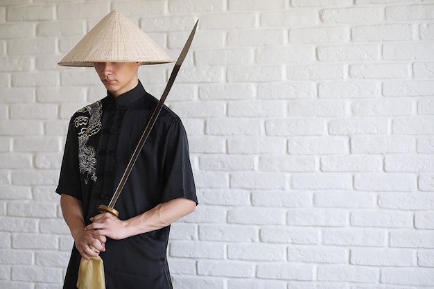 Asian young novice on a white brick wall background