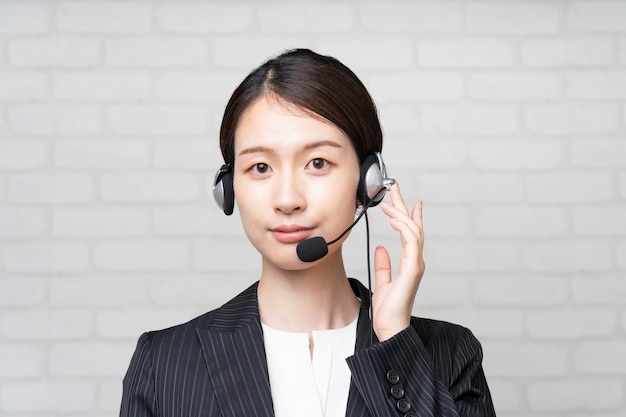 Asian young operator in suit wearing a headset