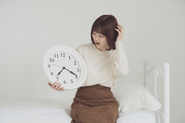 Asian young woman astonished to check the clock and be late in time