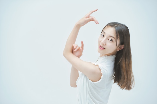 Asian young woman dancing gracefully and white background