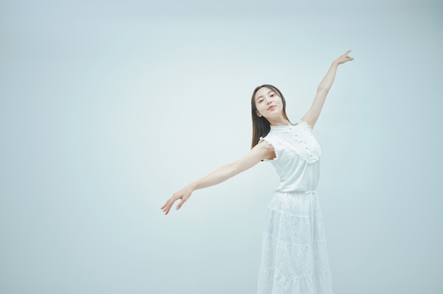 Asian young woman dancing gracefully and white background