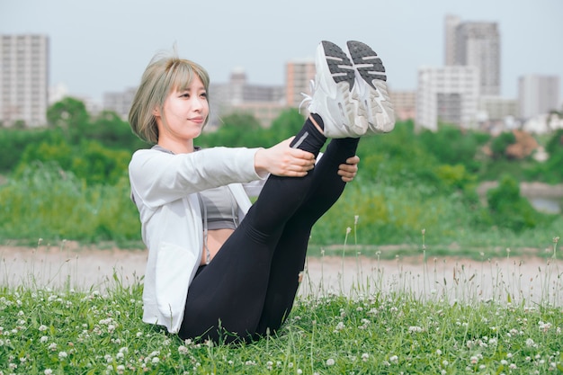 Азиатская молодая женщина работая outdoors