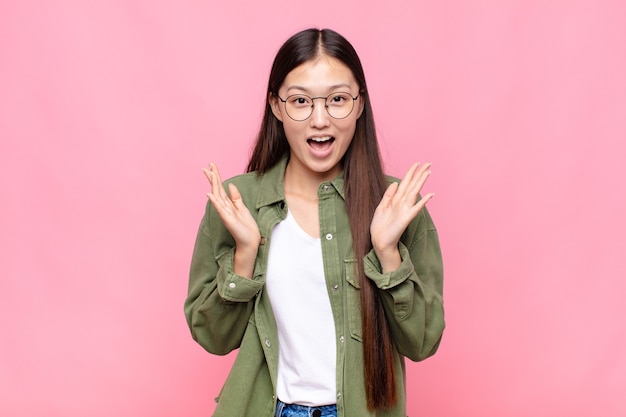 Asian young woman feeling happy, excited, surprised or shocked isolated