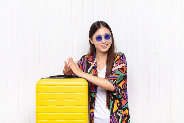 Asian young woman feeling happy and successful, smiling and clapping hands, saying congratulations with an applause. holidays concept