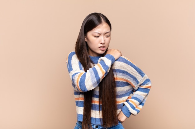 Giovane donna asiatica che si sente stanca, stressata, ansiosa, frustrata e depressa, che soffre di dolore alla schiena o al collo