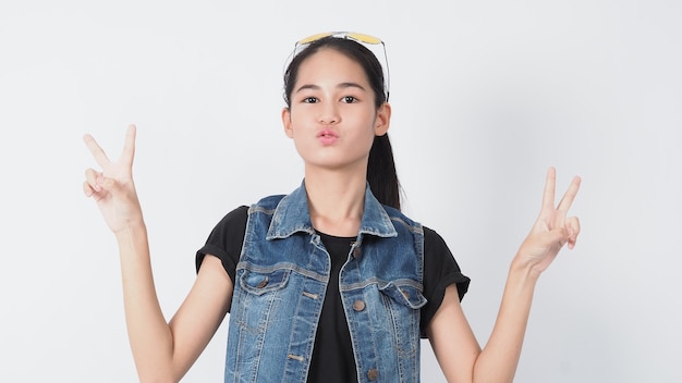 Asian Young woman gesture posing on white background. represent cheerful and confident. Showing gestures such as mini heart Okay Thumb up or point out. Happy amazed excited and surprised Jacket jeans.