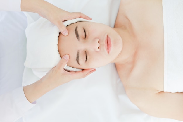 Photo asian young woman getting spa treatment at beauty salon. spa face massage. facial beauty treatment