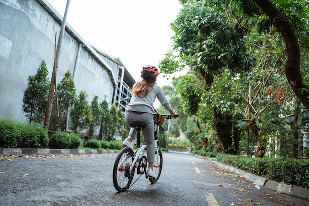 写真 アジアの若い女性がヘルメットをかぶって折りたたみ自転車で乗る