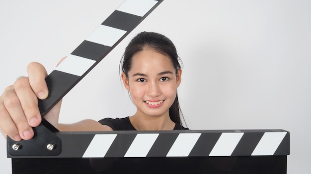 Asian young woman holding black clapper board or movie slate or clapperboard .it use in video production ,film, movie,cinema industry on white background.