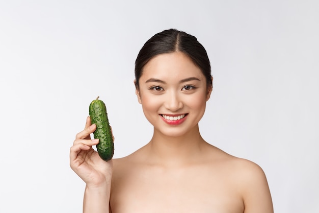 Asian young woman holding cucumber.