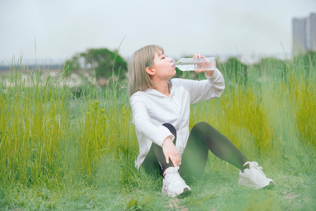 写真 運動中に水分補給アジアの若い女性