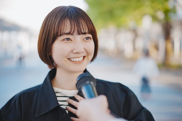 写真 街の通りでインタビューを受けたアジアの若い女性