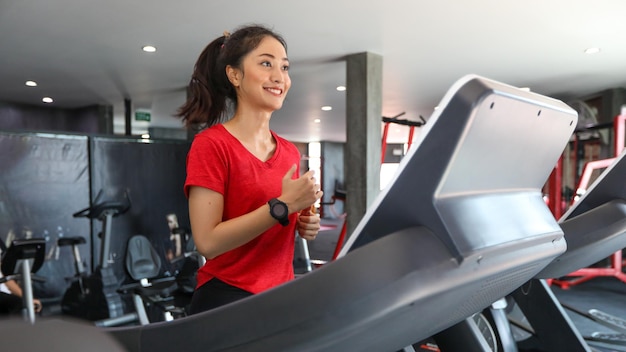 Asian young woman is having jogging on the treadmill