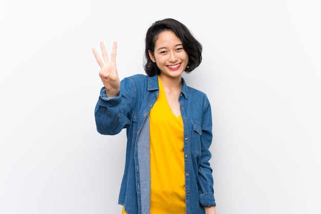 Asian young woman over isolated white background happy and counting three with fingers