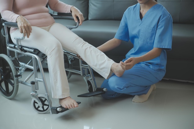 asian young woman nurse at nursing home take care disabled senior man caregiver doctor serve physical therapy for older elderly patient to exercise and practice walking on walker or cane at backyard