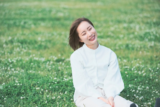 写真 牧草地のアジアの若い女性