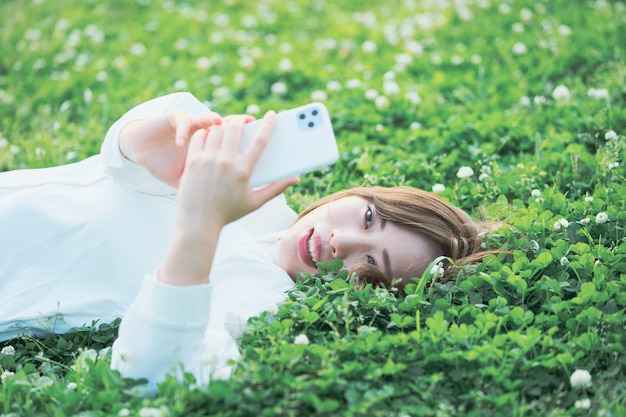 Asian young woman operating smartphone