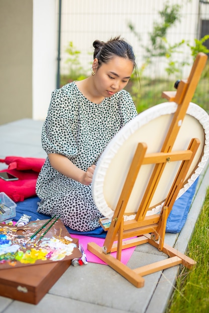 Asian young woman painting picture in home terrace