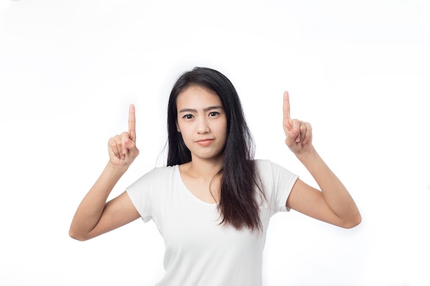 Asian young woman pointing at space on white background