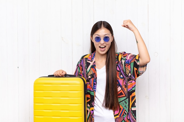 Asian young woman shouting triumphantly, looking like excited, happy and surprised winner, celebrating. holidays concept