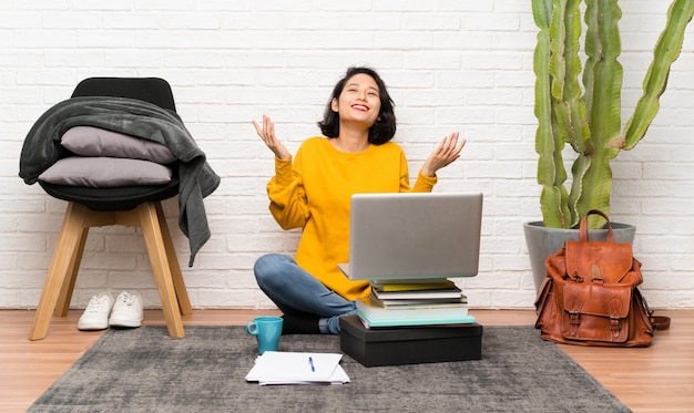 Asian young woman sitting on the floor laughing