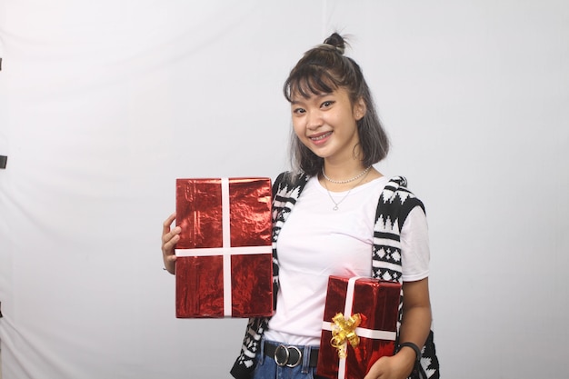 Азиатская молодая женщина улыбается приносит подарочные коробки на белом фоне.