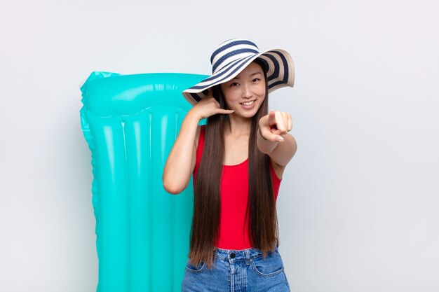 Asian young woman smiling cheerfully and pointing