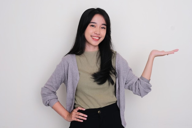 Asian young woman smiling with her left hand facing up holding something