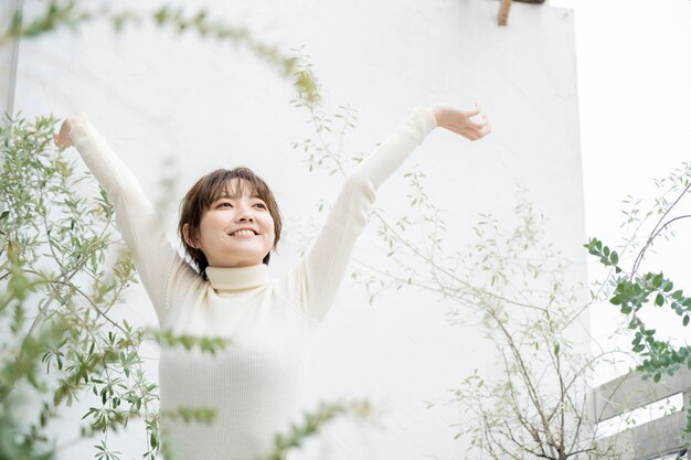 Photo asian young woman taking a deep breath on the veranda