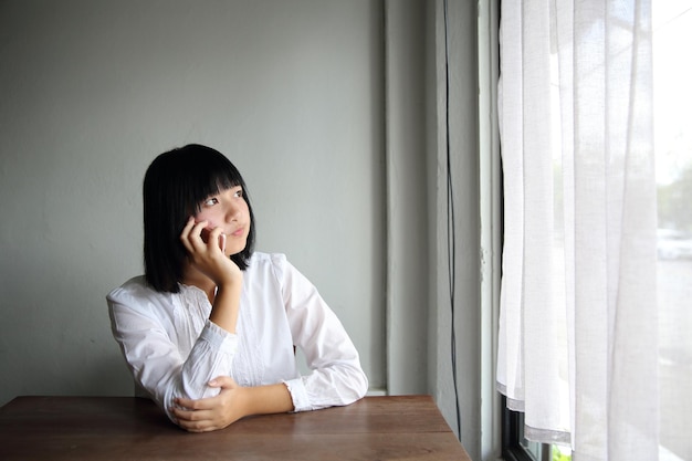 Asian young woman talking with smartphone portrait in coffee shop cafe